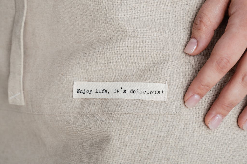 Crop woman touching cloth with inscription